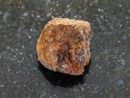 pierre brute de minerai de fer de limonite sur l'obscurité photo