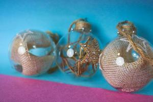 trois petits verres ronds transparents vintage improvisés élégants hipster décoratifs belles boules festives du nouvel an, décorations de noël avec du foin, de la paille à l'intérieur et avec une étoile photo