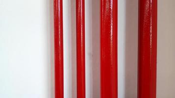grand et petit pipeline rouge sur mur blanc avec espace de copie à droite. conduite de gaz ou d'eau et groupe d'objets. photo