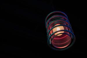 lampe à suspension loft avec lueur bleue rouge dans l'ombre des barres d'armature en acier, arrière-plan intérieur en bois, espace de copie photo