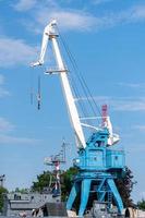 grue de réparation dans le chantier naval. reconstruction d'un ancien navire de guerre ou déchargement de cargaison à terre. en attente de pièces détachées photo