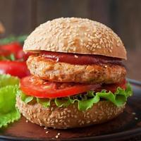 sandwich avec burger au poulet, tomates et laitue photo