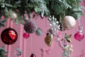 arrangement élégant d'arbre de noël de sapin naturel sur le fond d'un mur rose avec des décorations d'arbre de noël photo