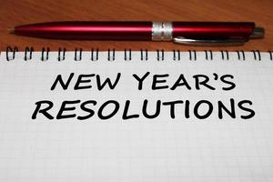 bloc-notes avec un stylo sur une table en bois. vue d'en-haut. le concept de résolutions pour la nouvelle année. photo