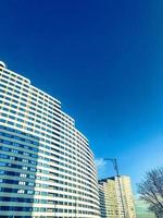 longue maison blanche sous la forme d'une vague contre un ciel bleu clair. nouveau bâtiment de blocs de couleurs claires, avec des baies vitrées de plain-pied. design à la mode inhabituel du nouveau photo