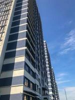 maison de pilier de verre bleu au centre de la ville en bleu et blanc. belle nouvelle zone, élégante et insolite. avec de nombreuses fenêtres pour les résidents. dans le contexte d'un ciel lumineux ensoleillé photo