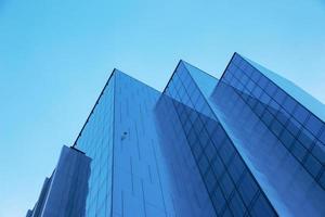 en levant un immeuble de bureaux moderne bleu. bâtiment en verre et métal photo