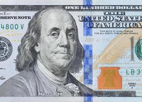 portrait du président américain benjamin franklin sur un fragment de macro gros plan de billets de 100 dollars. billet de cent dollars des états unis photo