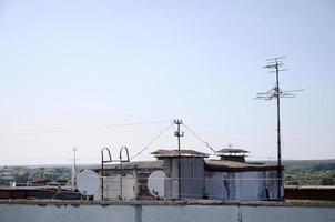 antennes paraboliques blanches avec deux convertisseurs montés sur le mur de béton du toit de l'immeuble résidentiel. Télévision par satellite photo