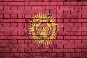 Le drapeau du Kirghizistan est peint sur un vieux mur de briques photo