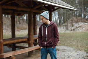 jeune beau mec dans un bonnet tricoté dans le parc photo