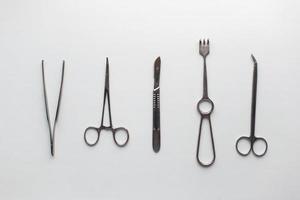 pincettes d'instruments chirurgicaux, pinces, pince la lame, scalpel, ciseaux sur une table blanche. photo