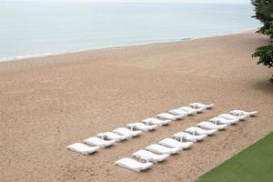 chaises longues sur la plage de sable. photo