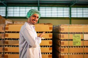 travailleur présentant des produits sur la chaîne de production de l'usine de boissons. le fabricant vérifie la qualité de l'industrie alimentaire. photo