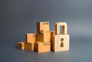 une pile de cartons et un cadenas en bois. concept d'achats d'assurance. fournir une garantie sur les produits achetés. protection des droits des consommateurs. dédouanement d'arrestation de cargaison. interdiction d'importer. photo