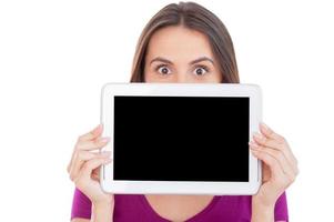 place de maintien pour votre annonce. surpris jeune femme regardant par la tablette numérique et souriant debout isolé sur blanc photo