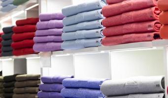 intérieur du magasin de t-shirts polo. étagères de magasin avec chemise en coton à la mode colorée photo