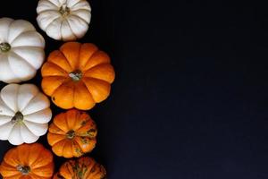 composition à plat d'halloween de chauves-souris en papier noir et de citrouilles sur fond orange. notion d'Halloween. photo