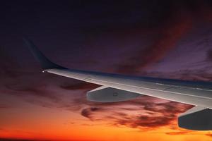 Aile d'avion surplombant un fabuleux coucher de soleil haut dans le ciel au-dessus de la péninsule balkanique photo