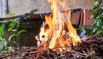 brûler des feuilles sèches dans la cour. grand feu. photo