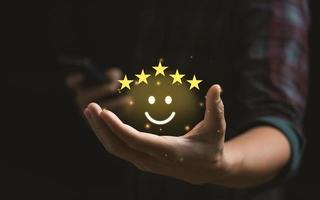 notion de satisfaction client. main avec le pouce vers le haut icône de visage souriant d'émotion positive et cinq étoiles avec espace de copie. Satisfaction 5 étoiles, excellente expérience d'évaluation des affaires photo