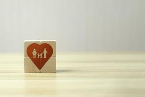 concept de famille heureuse de bonheur, d'amour. symbole de coeur rouge sur cube en bois sur beau fond et espace de copie. photo