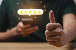 notion de satisfaction client. main d'homme à l'aide d'un smartphone avec icône pop-up cinq étoiles pour commentaires. avec espace de copie. Satisfaction 5 étoiles, excellente expérience d'évaluation des affaires photo