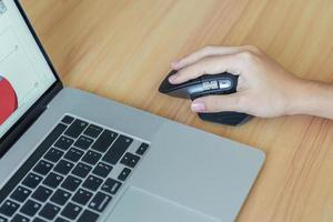 main de femme utilisant une souris verticale ergonomique pendant le travail sur un bureau réglable, prévention des douleurs au poignet. ténosynovite de quervain s, symptôme d'intersection, tunnel carpien ou concept de syndrome de bureau photo