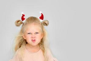 petite fille avec des cornes de taureau de petits chapeaux de père noël photo