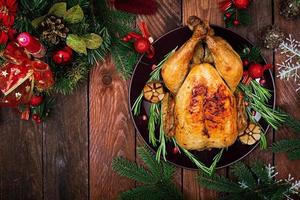 dinde ou poulet au four. la table de noël est servie avec une dinde, décorée de guirlandes lumineuses et de bougies. poulet frit, table. dîner de Noël. mise à plat. vue de dessus photo