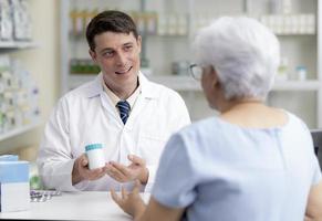 jeune pharmacien caucasien donne des conseils aux patients. photo