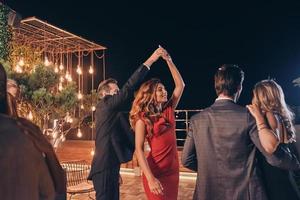 beaux jeunes gens dansant et souriant tout en passant du temps sur une fête de luxe photo