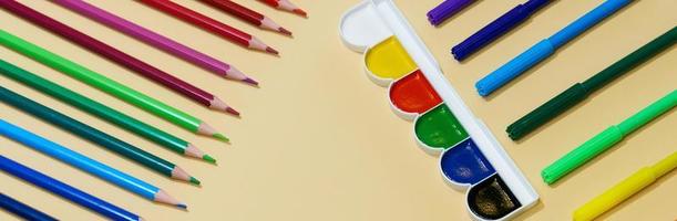 crayons de couleur et marqueurs avec stylos et peinture sur fond de papier avec copie photo