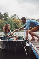 meilleure façon de passer la date. heureux jeune couple se prépare à ramer un bateau tout en profitant de leur rendez-vous à l'extérieur photo