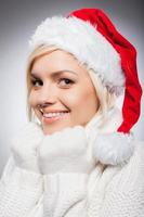 fille en bonnet de noel. belle jeune femme en bonnet de noel regardant la caméra et souriant tout en étant isolée sur gris photo