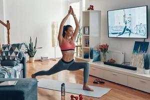 belle jeune femme en forme de vêtements de sport travaillant tout en passant du temps à la maison photo