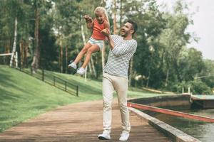 s'amuser ensemble. toute la longueur du père et de la fille joyeux s'amusant ensemble dans le parc photo