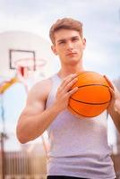 joueur de basketball. beau jeune joueur de basket-ball prêt pour le tir photo