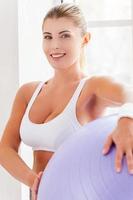 femme avec ballon de fitness. jolie femme mûre tenant un ballon de fitness et souriant à la caméra photo