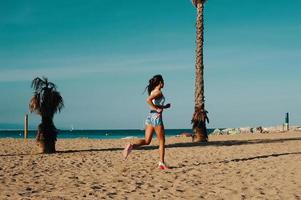 vers un mode de vie plus sain. toute la longueur de la belle jeune femme en vêtements de sport faisant du jogging tout en faisant de l'exercice à l'extérieur photo