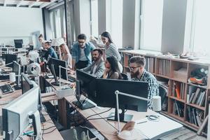 inspiré pour obtenir les meilleurs résultats. groupe de jeunes gens d'affaires en vêtements décontractés intelligents travaillant et communiquant assis au bureau au bureau photo