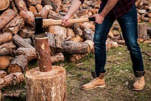 bûcheron au travail. gros plan d'un jeune forestier coupant un journal tout en se tenant à l'extérieur photo