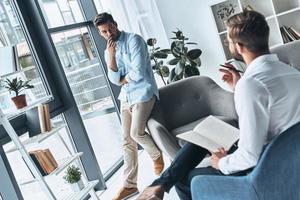 écoutant le médecin. jeune homme frustré regardant un psychologue assis sur la séance de thérapie photo