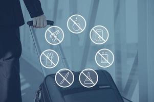 avertissements de sécurité. icône composée numériquement sur une photo d'homme d'affaires tirant sa valise à l'aéroport