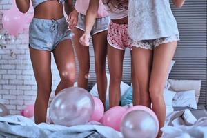 jambes parfaites. gros plan de quatre jeunes femmes en pyjama se liant lors d'une soirée pyjama photo