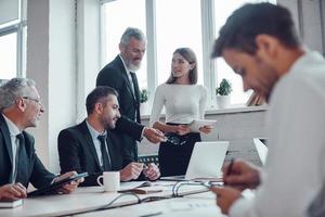 des collègues confiants discutant de la prochaine étape commerciale tout en travaillant ensemble dans le bureau moderne photo