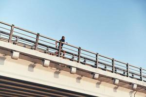 pousser fort pour être le meilleur. jeune homme africain en vêtements de sport faisant de l'exercice en courant sur le pont à l'extérieur photo