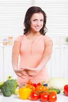 prêt à cuire. belle jeune femme s'échauffant avant de cuisiner en se tenant debout dans la cuisine photo