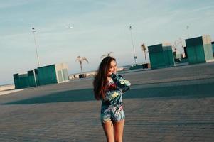 journée sans souci. jolie jeune femme en vêtements de sport regardant la caméra et souriant tout en marchant à l'extérieur photo