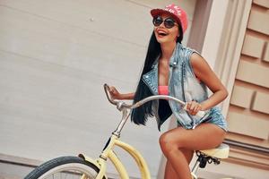 jouissant de la liberté. vue en angle bas d'une jeune femme joyeuse souriante et impatiente de faire du vélo à l'extérieur photo